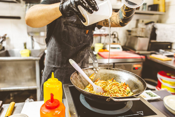street food. fried noodles in a wok with chicken and shrimp on the wok. - 写真・画像