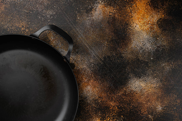 Cast iron frying pan set with copy space for text or food with copy space for text or food, top view flat lay, on old dark rustic table background - Photo, Image