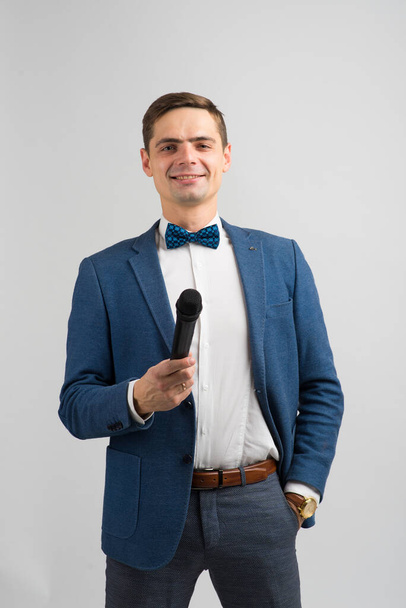 Portrait of professional male reporter holding microphone, isolated on white and green background - Fotó, kép