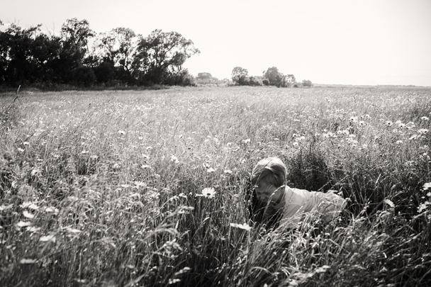 Boy in a field with daisies - Foto, Imagem