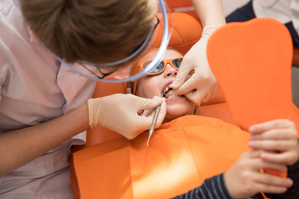 Mädchen öffnete den Mund, um mit einem Zahnarzt zu überprüfen, überwachen Zähne Gesundheit. Kinder Zahnpflege und Hygiene - Foto, Bild