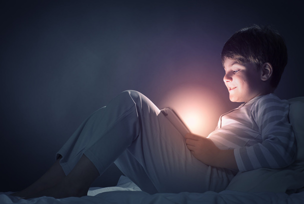Boy using tablet pc in bed - Fotografie, Obrázek