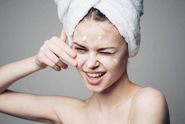 woman with bare shoulders towel on head face cream skin care - Фото, зображення
