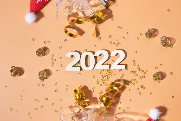 Εορταστική ευτυχισμένη νέα χρονιά επίπεδη θέσει με αριθμούς 2022 και σκληρές σκιές με γυαλιστερή διακόσμηση - Φωτογραφία, εικόνα