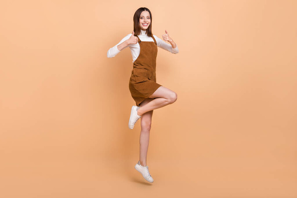 Full body photo of carefree cheerful pretty lady two hands show thumbs up isolated on beige color background - Photo, image