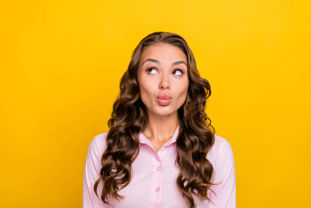 Photo of flirty millennial brunette lady blow kiss wear pink shirt isolated on yellow color background - Zdjęcie, obraz