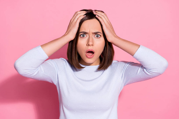 Photo of shocked amazed young woman wear white sweater arms head hearing lockdown news isolated pink color background - Foto, Imagen