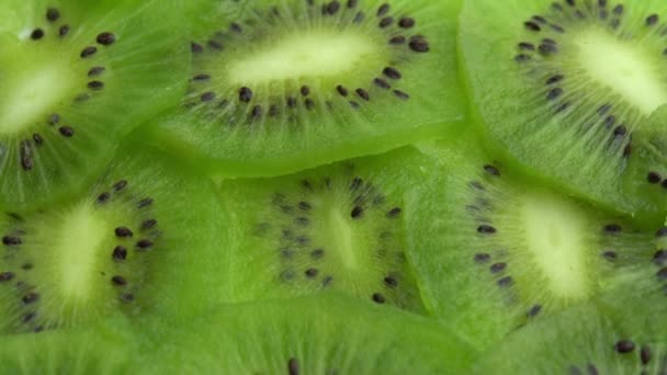Sfondo sotto forma di giri di kiwi affettati, succoso kiwi verde o uva spina cinese - Filmati, video
