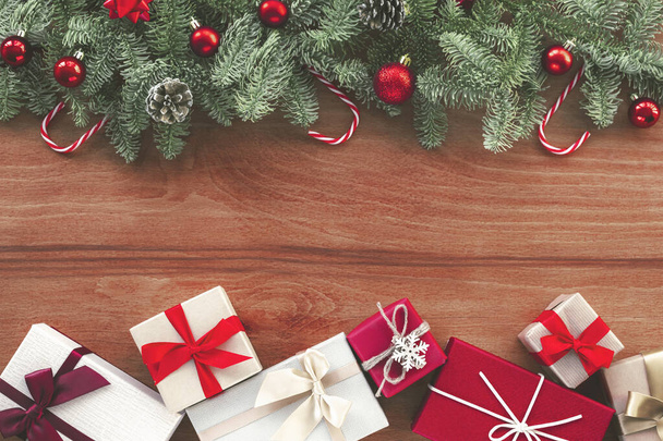 Weihnachtlicher Hintergrund mit Tannenzweigen, Neujahrsschmuck und Geschenkschachteln auf Holzkulisse. Draufsicht, flache Lage, Kopierraum. - Foto, Bild