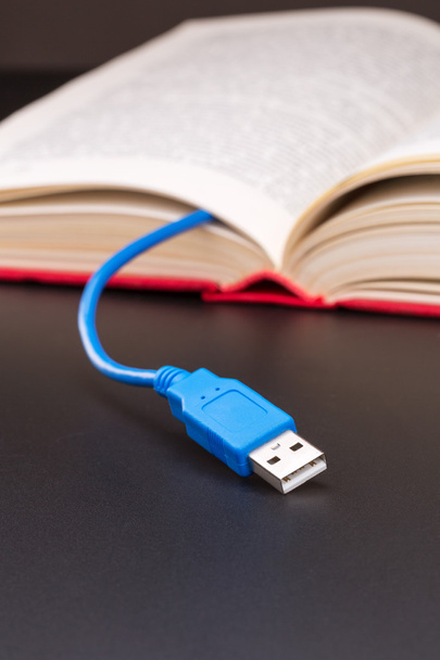 USB кабель торчит из красной книги
 - Фото, изображение