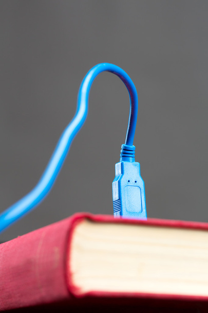 Cable USB conectado a un libro
 - Foto, Imagen