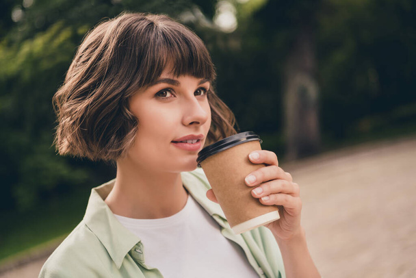 Profile side view portrait of attractive dreamy brown-haired girl drinking hot cacao resting fresh air outdoors - Foto, afbeelding
