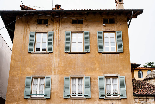 Régi épület redőnnyel az ablakokon. Bergamo, Olaszország - Fotó, kép