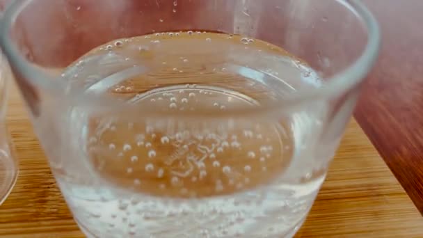 Eine Tasse flachen weißen Kaffee und ein Glas sprudelndes Wasser - Filmmaterial, Video