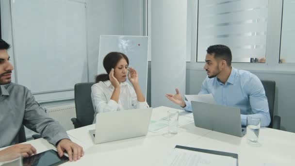 Nespokojený mladý arabský šéf pokáral zaměstnance za špatnou práci při setkávání různých skupin, naštvaný vedoucí týmu zmačkává papírové pokárání podřízeným za špatný finanční výsledek na schůzce úřadu - Záběry, video