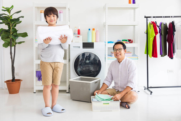 Asiático pai e filho ajudar uns aos outros fazendo lavanderia juntos para tarefas diárias de rotina - Foto, Imagem