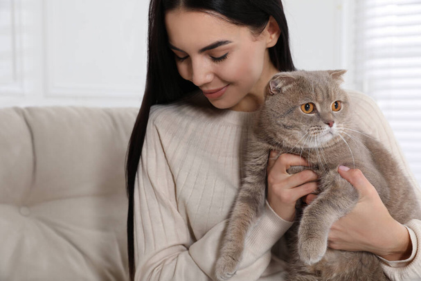 Woman with her adorable cat on sofa at home - Foto, Bild