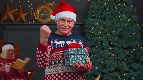 Senior Opa im Weihnachtspullover feiert Erfolg Sieg Schreien Sieger Hände Geste - Filmmaterial, Video
