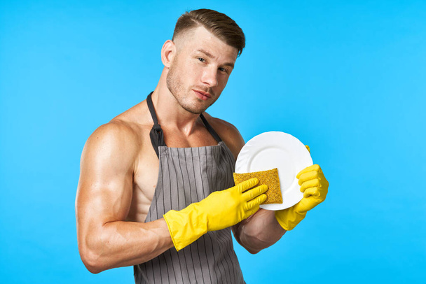 man in apron cleaning dishwashing blue background - Photo, image