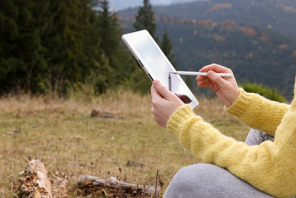 Woman drawing with graphic tablet in mountains, closeup - 写真・画像