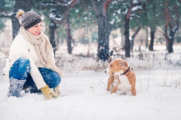 Woman playing with her pet in snow - Foto, Bild