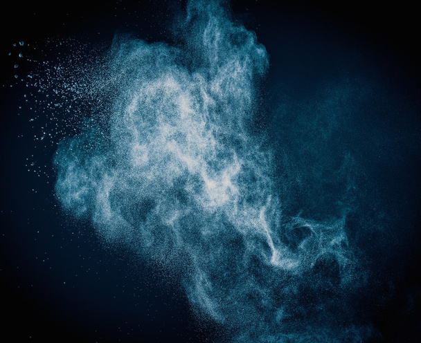 Blue powder exploding isolated on black - Photo, Image