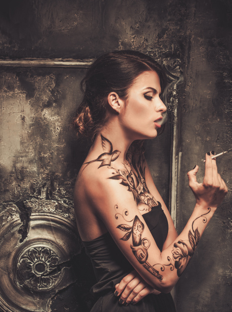 Паління татуйована красива жінка в старому дикому інтер'єрі
 - Фото, зображення