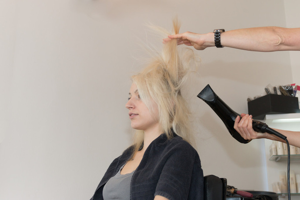 Blonde girl getting hair blow dried - Photo, Image