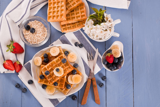 Waffles with blueberries, bananas and honey. - Fotó, kép