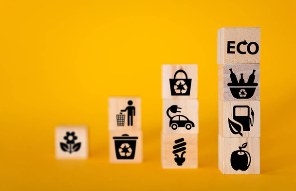 Conceito de ecologia com ícones em cubos de madeira, fundo amarelo. O conceito de energia limpa para o mundo inteiro. - Foto, Imagem