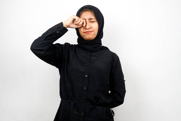 Όμορφη νεαρή μουσουλμάνα γυναίκα κλαίει, τα χέρια σκουπίζουν δάκρυα, απομονώνονται σε λευκό φόντο - Φωτογραφία, εικόνα