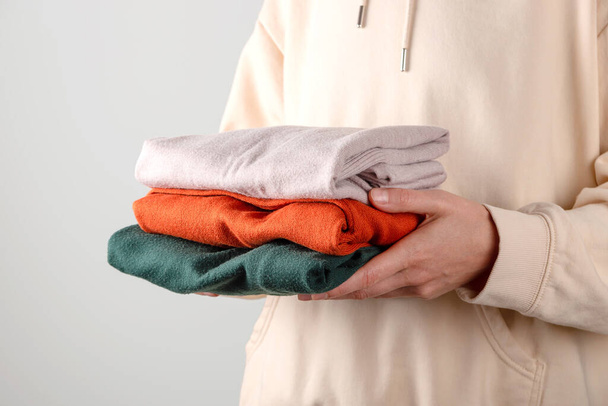Stack of autumn basic womens turtlenecks in trendy colors in female hands. Minimalist basic wardrobe. Household laundry - Photo, Image