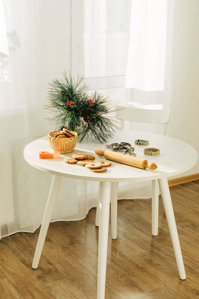 Pâtisseries de Noël ou du Nouvel An sur une table décorée de branches de pin. Noël, pain d'épice, moules pour la cuisson festive - Photo, image