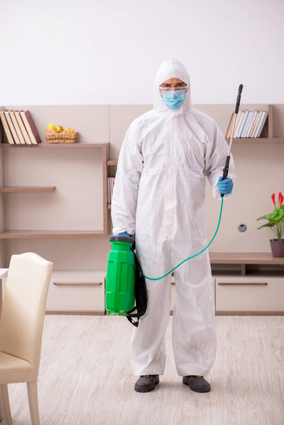 Young male contractor disinfecting at home - Fotoğraf, Görsel