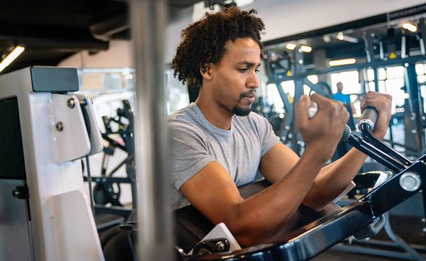 Young healthy fit man working out in the gym - 写真・画像
