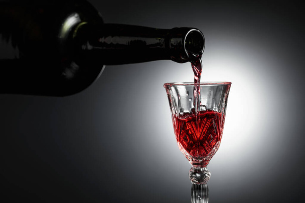 El vino de postre o licor se vierte en un vaso de una botella antigua. Copiar espacio. - Foto, imagen