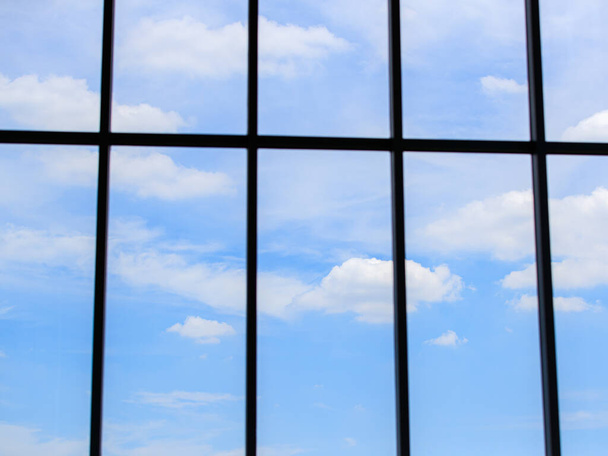 Фон красивого світло-блакитного неба і хмар на яскравий день через повне прозоре скло вікно, показуючи про архітектуру, навколишнє середовище, клімат і концепцію свіжості
 - Фото, зображення