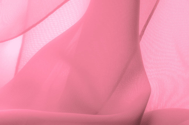 絹の赤いポリエステル。色ピンクのシルク生地からの背景。透明感と軽さのある縫製用生地を使用しています。繊維パノラマ.テクスチャ.テンプレート. - 写真・画像