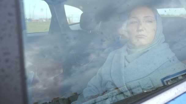 Kobieta otwiera okno, aby oddychać świeżym powietrzem i patrzy na deszcz - Materiał filmowy, wideo