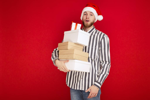 Πορτρέτο ενός άντρα με χριστουγεννιάτικο καπέλο που αγόρασε δώρα - Φωτογραφία, εικόνα
