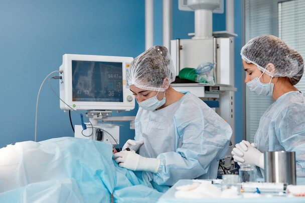 Η ιατρική ομάδα εκτελεί την επέμβαση - μια σειρά από εικόνες που σχετίζονται με τη χειρουργική επέμβαση. Πραγματικά σύγχρονο, λειτουργική αμοιβή, αγώνας για τη ζωή - Φωτογραφία, εικόνα