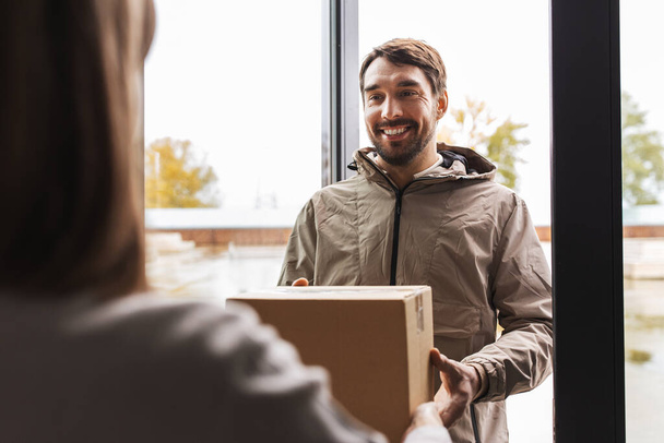 delivery man giving parcel box to customer at home - Foto, Bild
