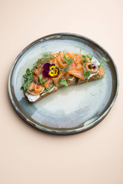 Sliced salmon with cream cheese on a toast decorated with flowers - Foto, immagini