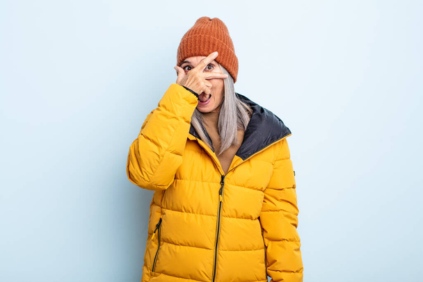 middle age gray hair woman looking shocked, scared or terrified, covering face with hand. cold weather concept - Photo, image