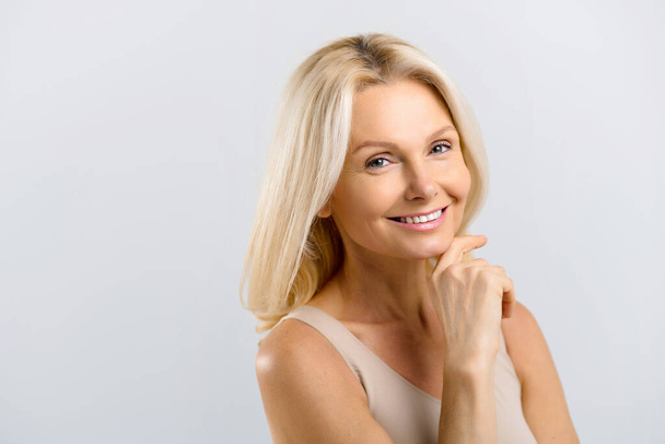 Woman isolated on grey background looking at the camera and smiles toothy - Photo, image