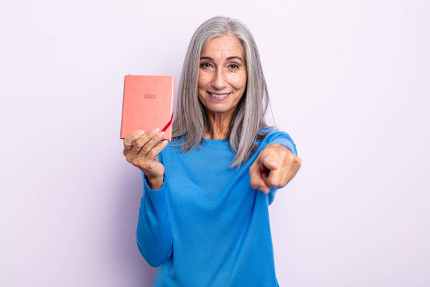 middle age gray hair woman pointing at camera choosing you. 2022 agenda concept - Foto, Bild