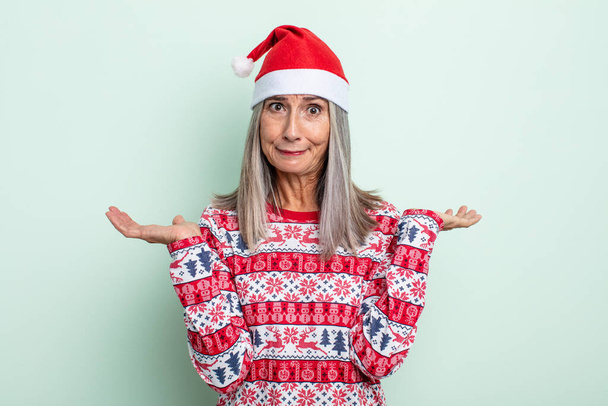 Женщина среднего возраста седых волос чувствует себя озадаченной, смущенной и сомневающейся. рождественская концепция - Фото, изображение