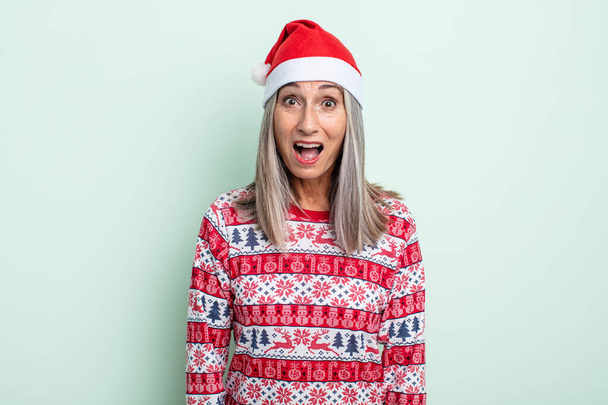 middle age gray hair woman looking very shocked or surprised. christmas concept - Foto, Bild