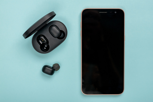 Redmi AirDots pro wireless earbuds with Bluetooth 5.0 support Can be used for bilateral calls and digital sound quality is assured with its DSP digital noise reduction and capsule on blue background. - Photo, Image