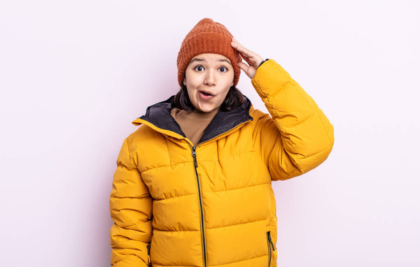 pretty young woman looking happy, astonished and surprised. cold weather concept - 写真・画像